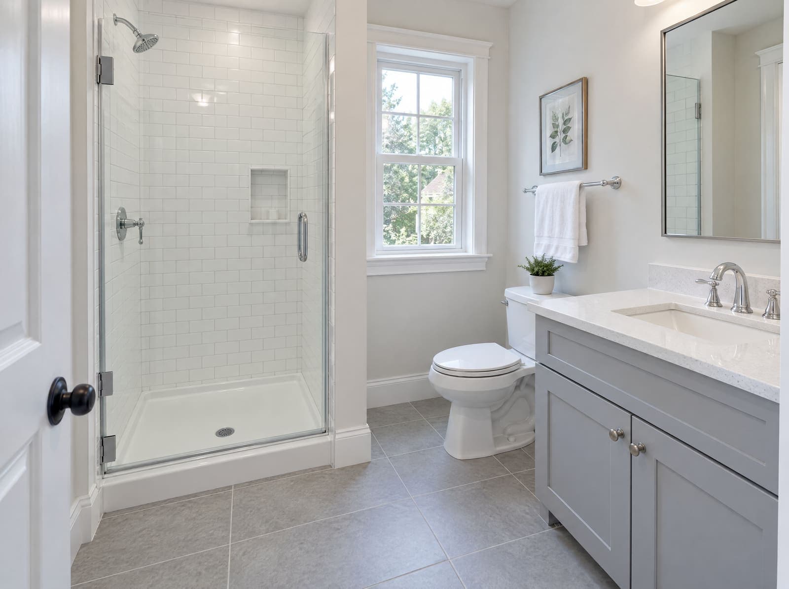 The same bathroom after a deep clean: shower glass clear, grout white, chrome polished, vanity empty and wiped, floor spotless.